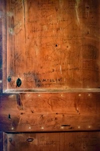 Firme su una porta interna del campanile di Baricella 3 settembre 2015 - foto: Kiodo